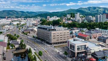 A cityscape with a prominent building featuring a modern design and a parking lot.