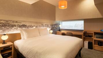 A modern hotel room with a large bed, a desk, a chair, a lamp, a small shelf with a coffee maker, and a cityscape mural on the wall.