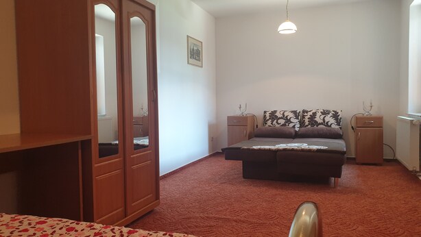 A bedroom with a bed, a wardrobe, a bedside table, and a radiator. - Siegmundsburger Haus Werraquelle here Apartment "Traumwelt" family- / pet-friendly (Siegmundsburg)