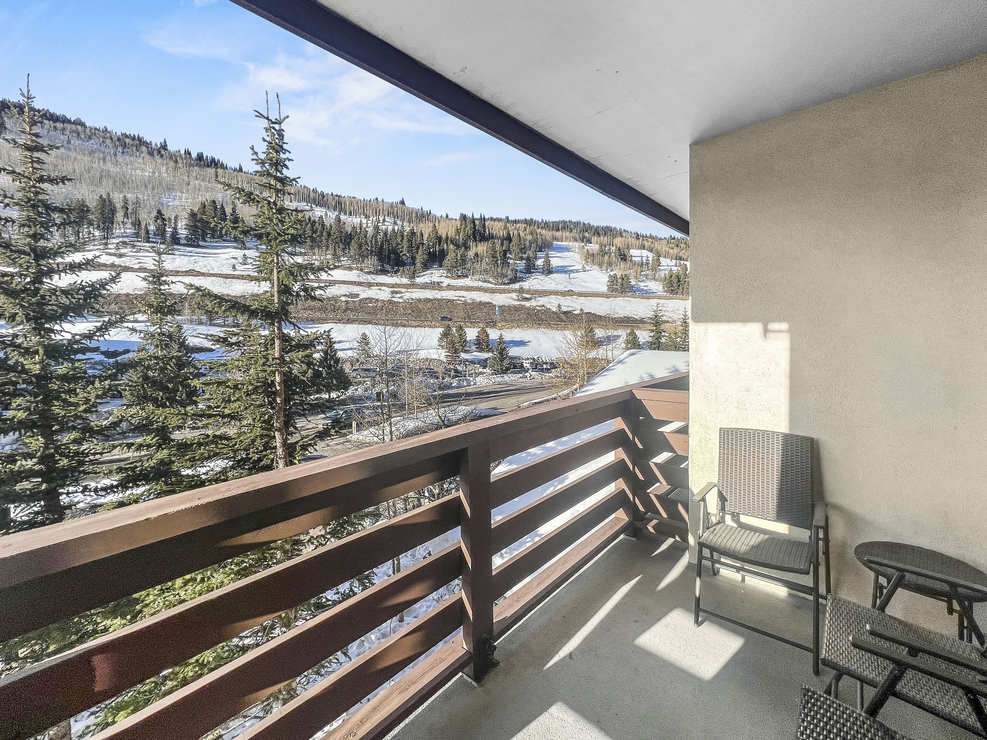 Un balcon donnant sur un paysage enneigé, avec une chaise.