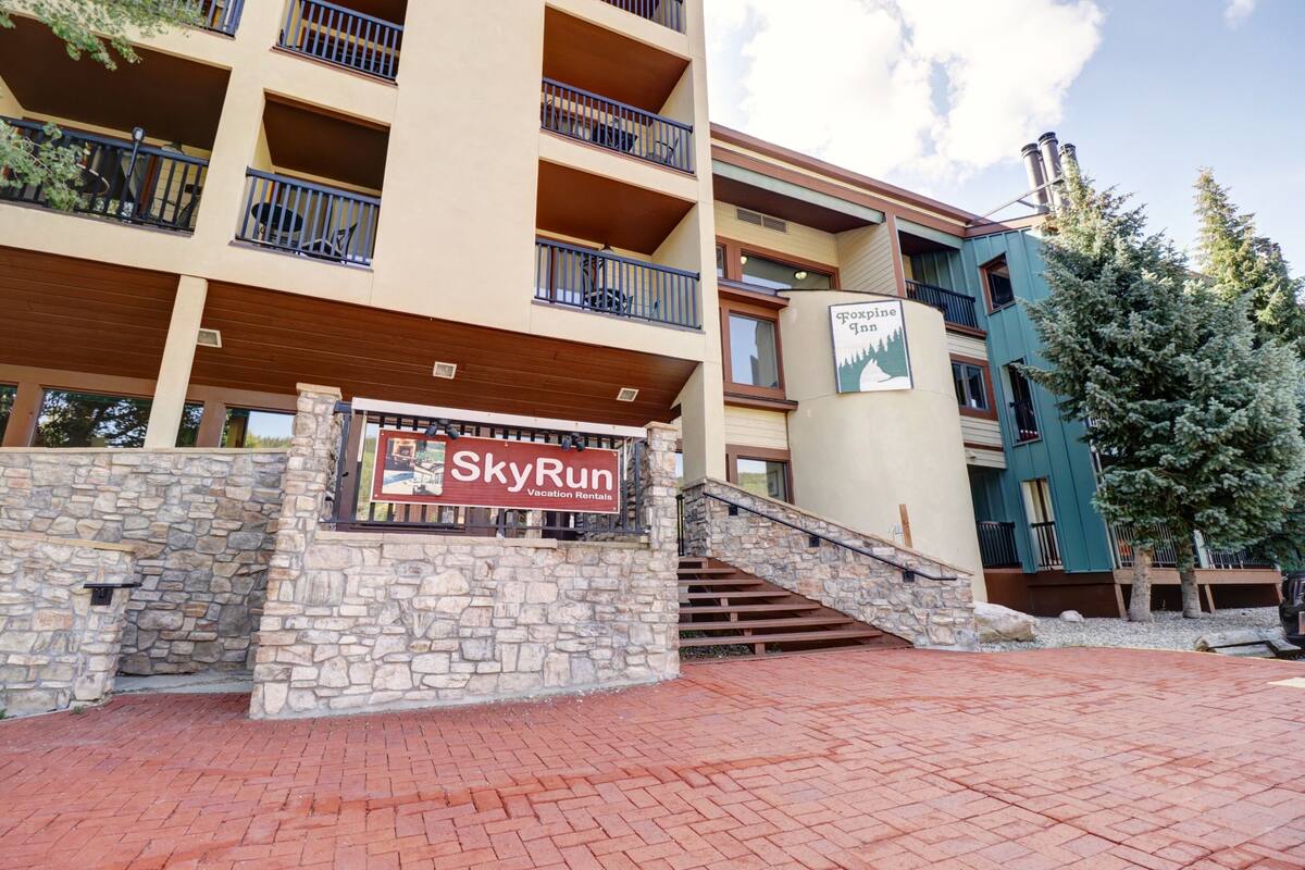 A multi-story building with a stone facade and a sign for SkyRun Vacation Rentals.