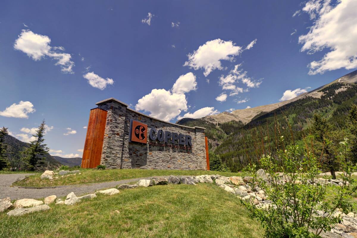 A stone building with a sign reading "Copper" in a mountainous area.