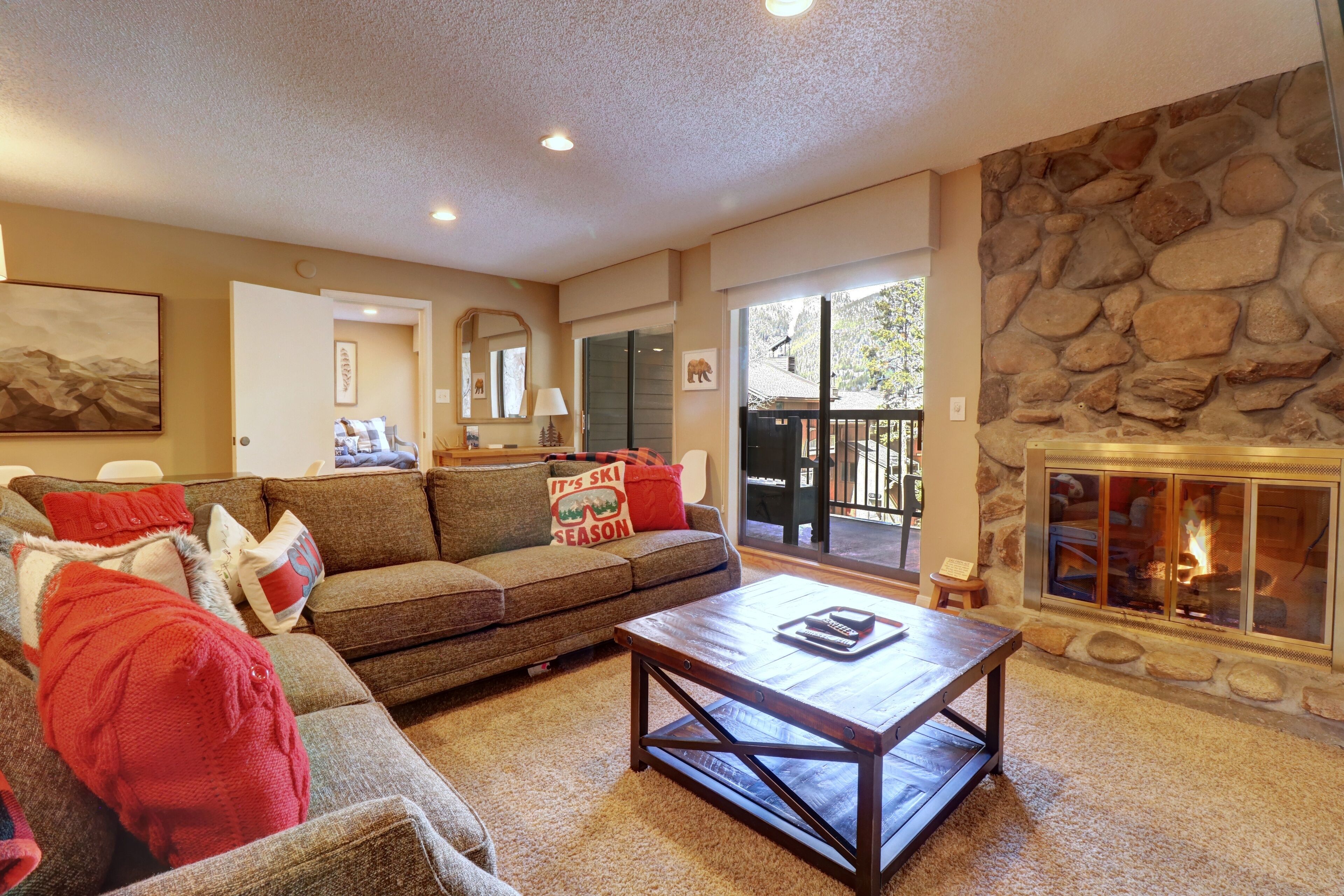 A cozy living room with a stone fireplace, a sofa, and a coffee table.