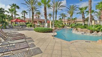 Relax by the resort pool surrounded by palm trees and lounge chairs.