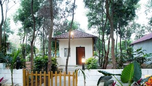 A small house with a tiled roof, surrounded by trees and plants. - Vanam Resort (Tupran)