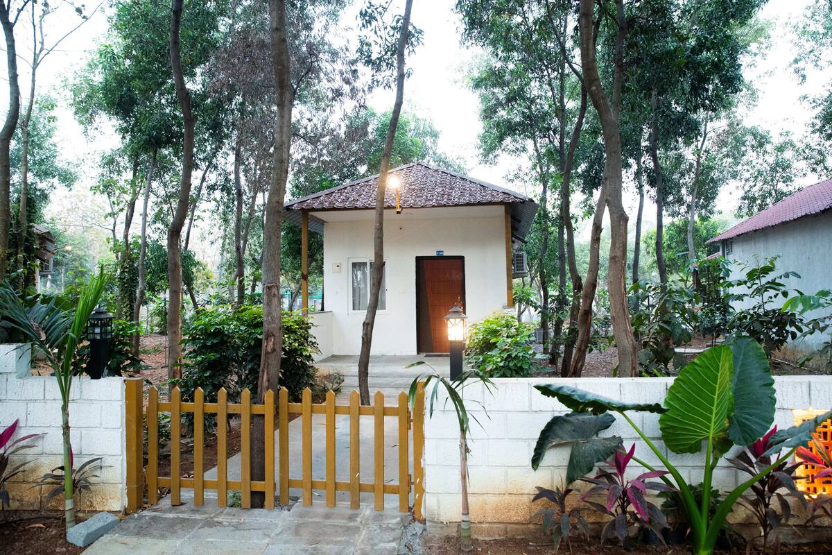 A small house with a tiled roof, surrounded by trees and plants.