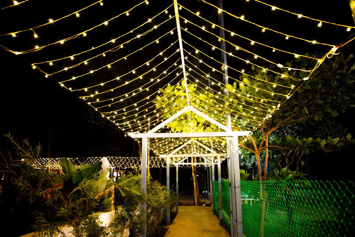 A covered outdoor area with string lights and a white structure.