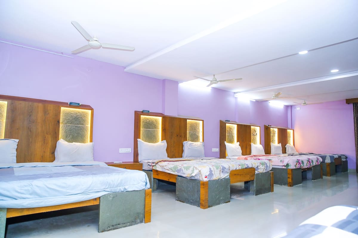 A hotel room with four beds, wooden headboards, and ceiling fans.