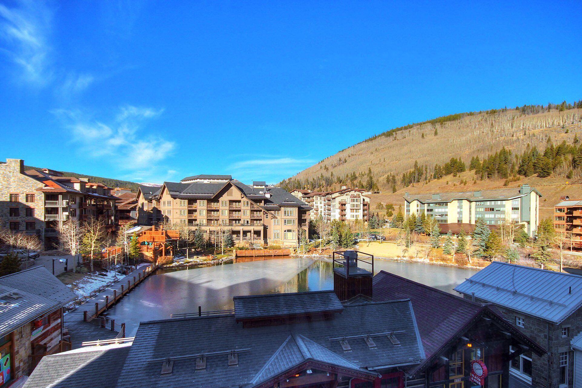 A resort with multiple buildings, a central courtyard, and a lake.