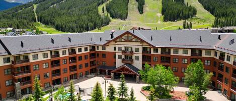 A large hotel with multiple floors, a central courtyard, and a pool.