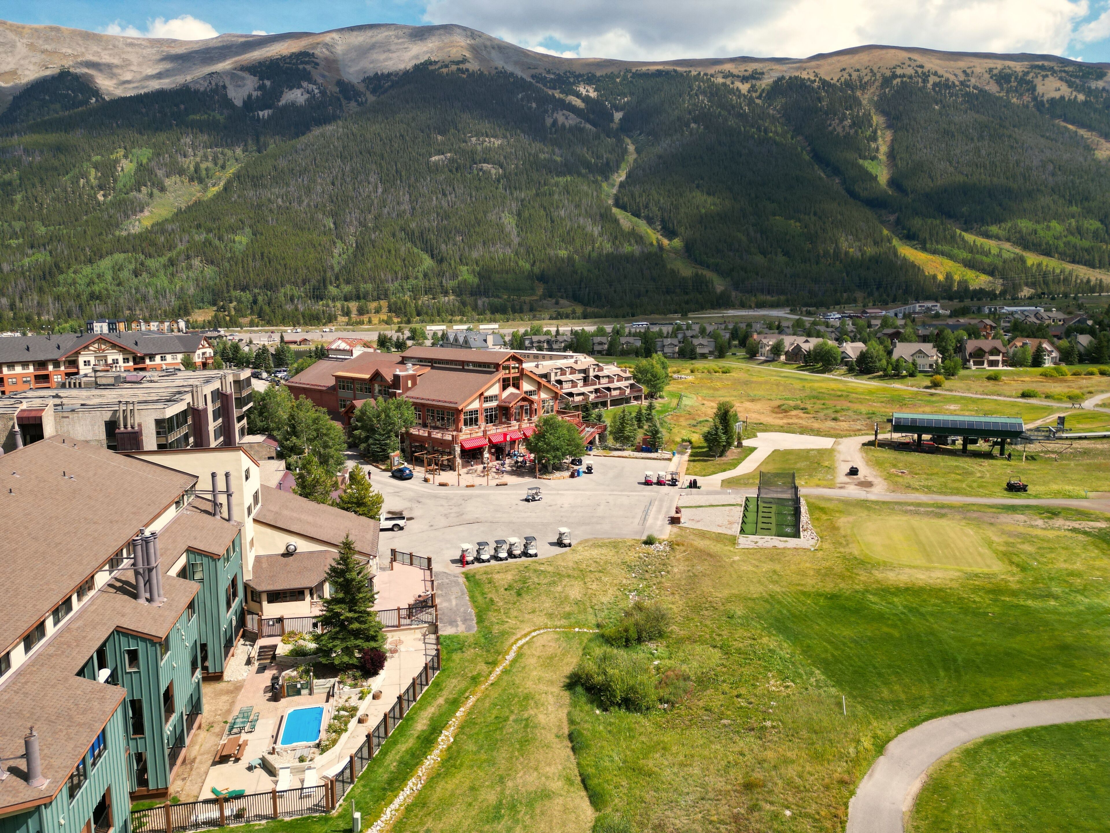 A hotel with a pool, surrounded by a mountainous landscape.