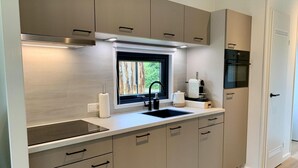 Eine moderne Küche mit integriertem Spülbecken, einem Fenster und einer Kaffeemaschine.