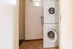 A laundry room with two stacked front-loading washing machines. - Holiday Retreat, Near Forest (Sint Maartensvlotbrug)