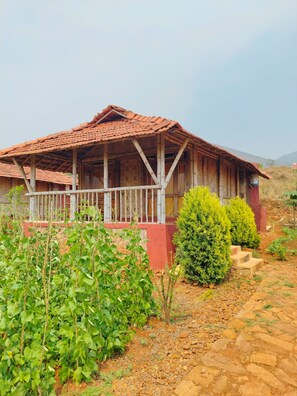 Une maison de campagne en bois, avec un toit en tuiles et une véranda.