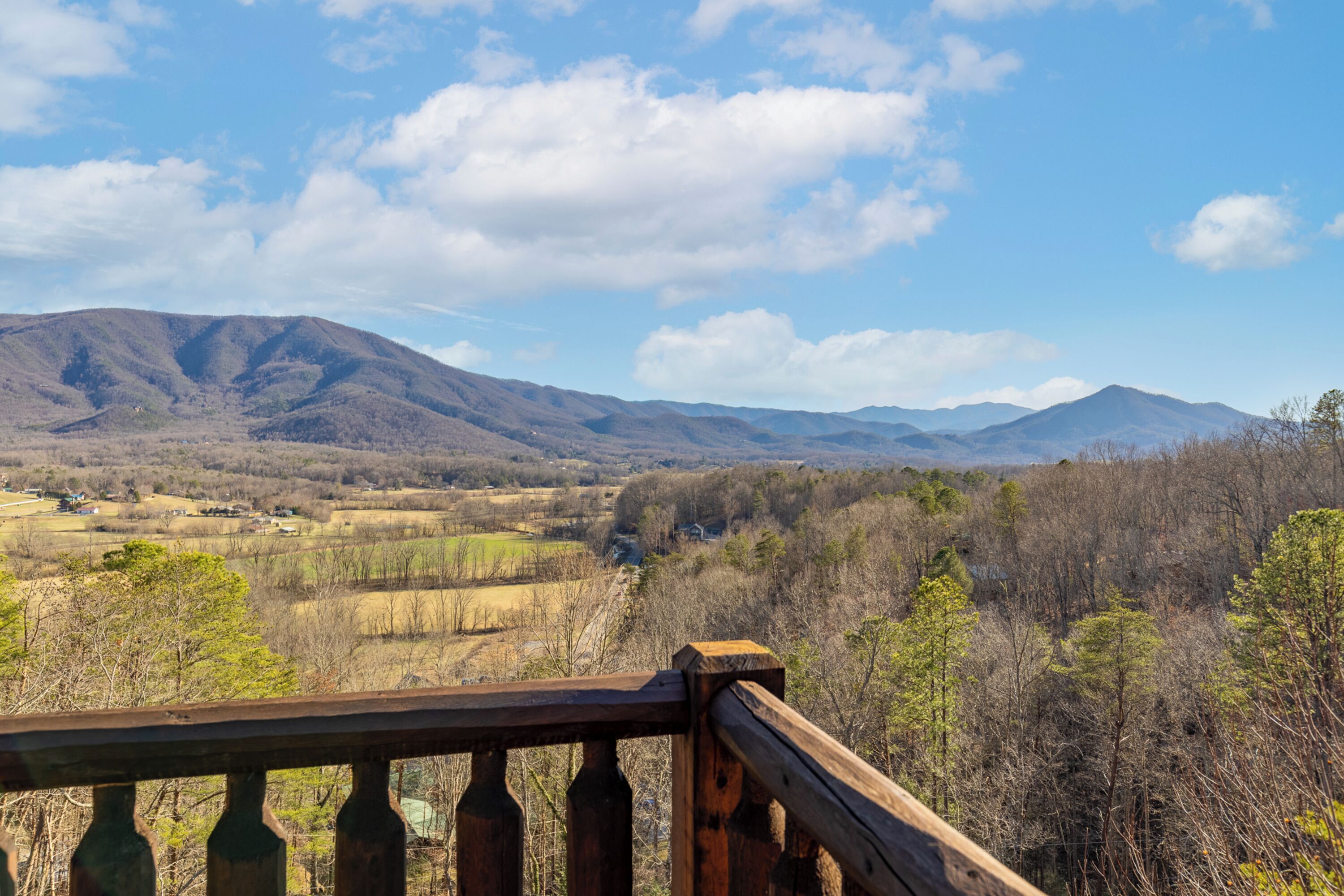 A wooden deck with a view of a mountainous landscape.