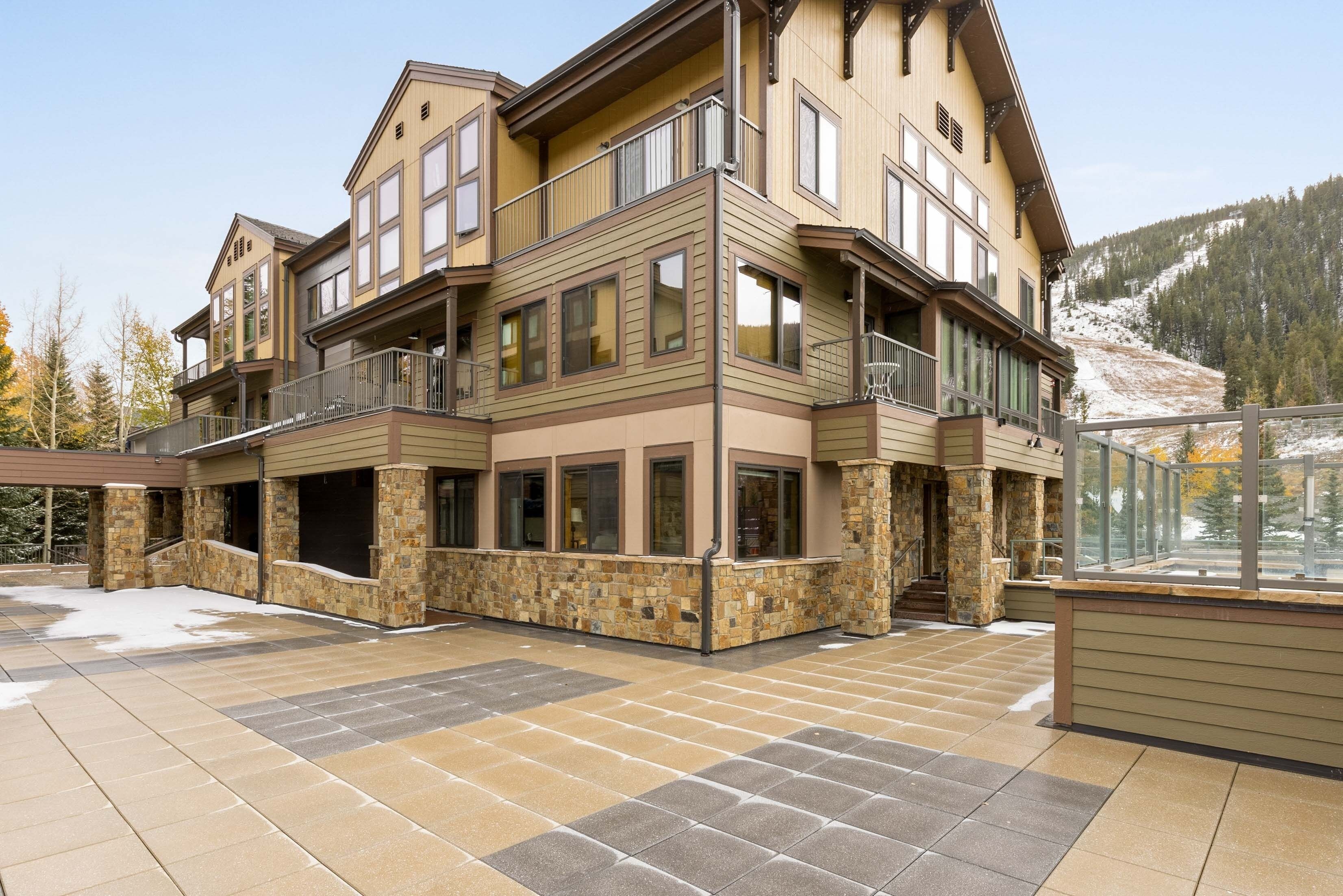 A multi-story building with a stone foundation, large windows, and balconies.