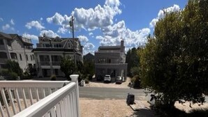 Un escalier en bois menant à un bâtiment, avec un ciel dégagé en arrière-plan.