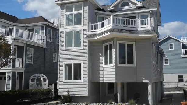 A multi-story residential building with a balcony, a garage, and a driveway. - 4 bedroom accommodation in Harvey Cedars (Harvey Cedars)