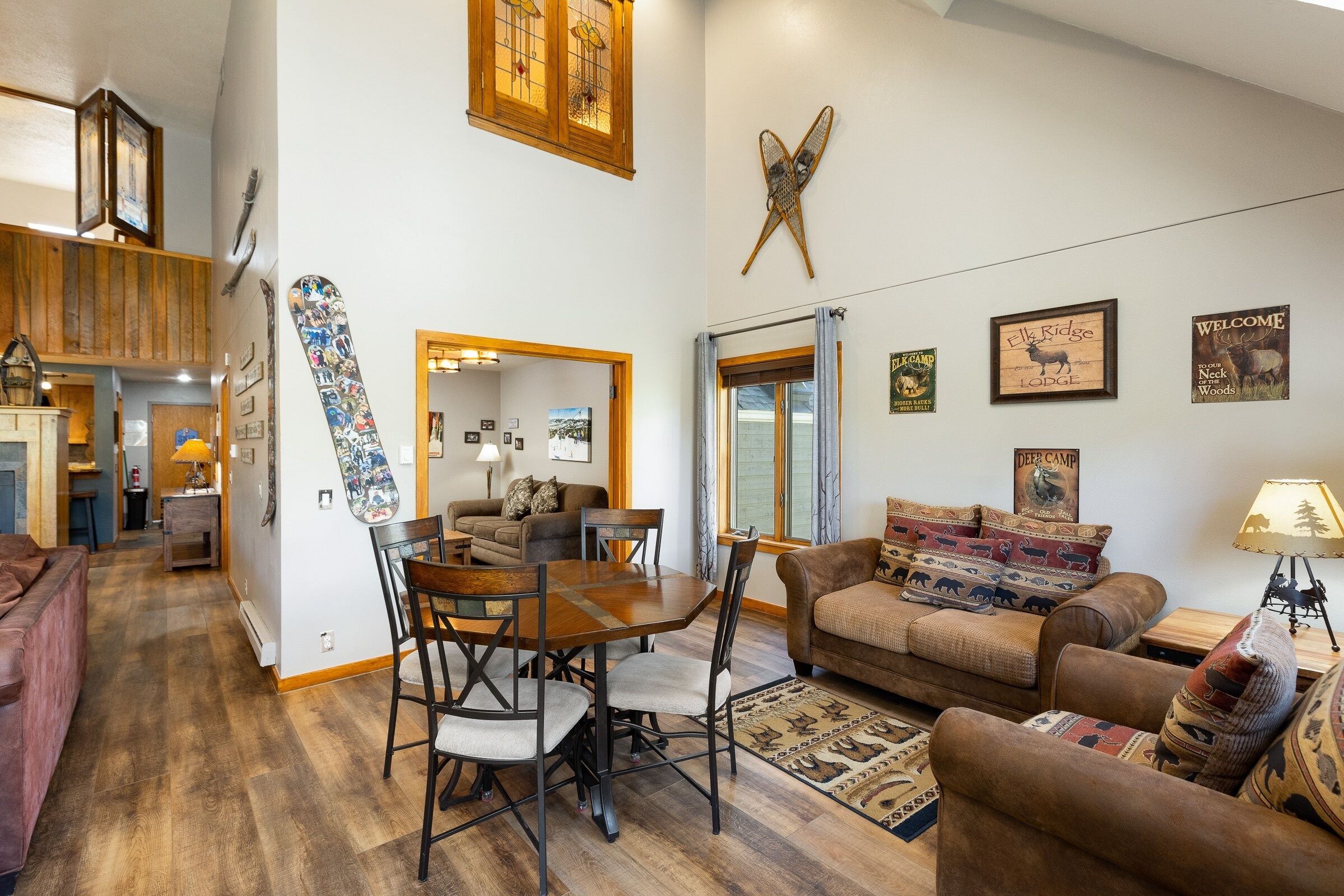 A cozy living room with a wooden dining table, two sofas, and a fireplace.