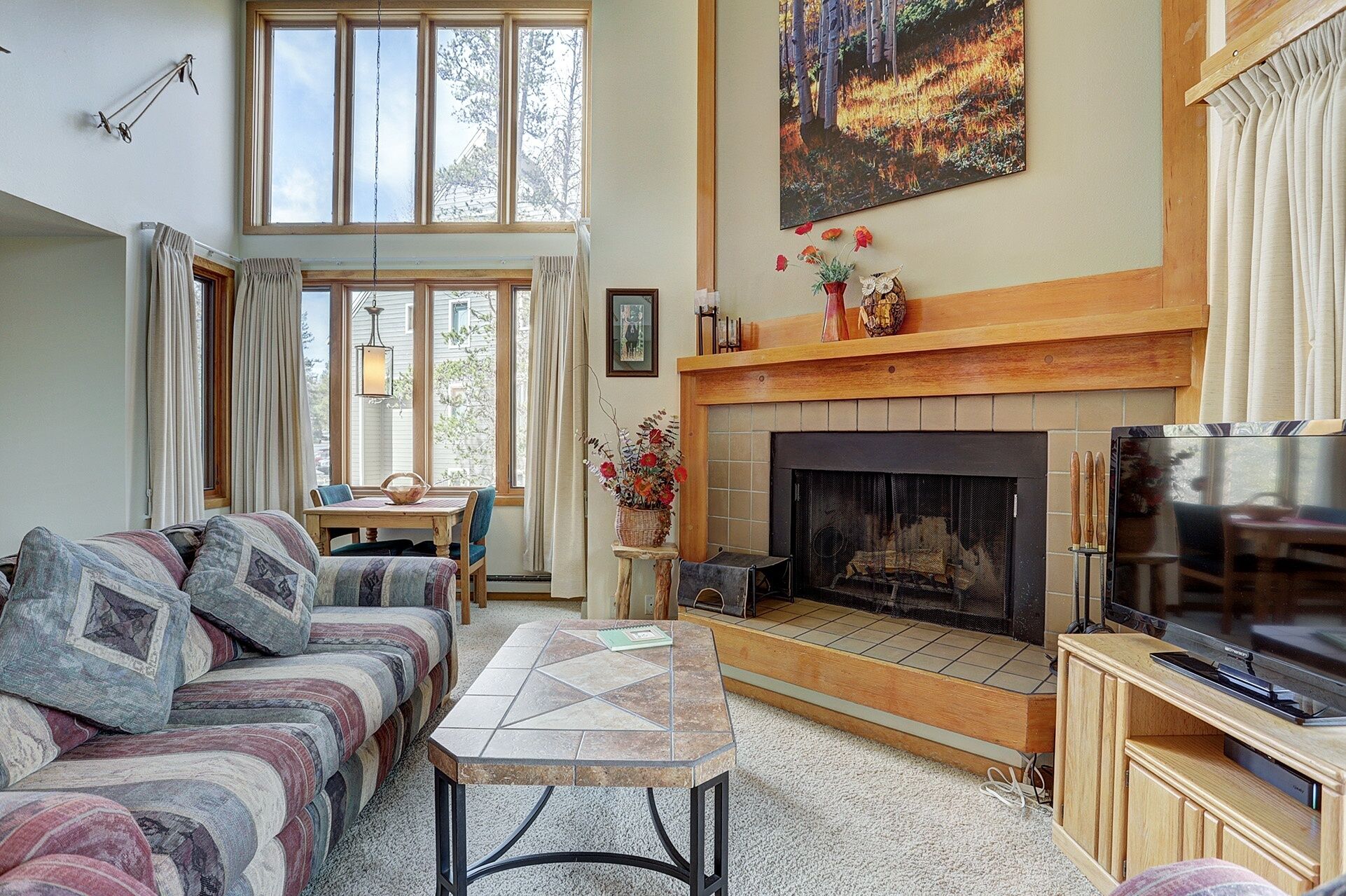 A living room with a fireplace, a sofa, a dining table, and a television.