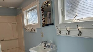 A bathroom with a bathtub, a sink, and a mirror. - Nice clean rear cottage just 3 homes to the beach in Ship Bottom (Ship Bottom)
