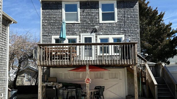 A two-story house with a covered front porch and a garage. - Nice clean rear cottage just 3 homes to the beach in Ship Bottom (Ship Bottom)