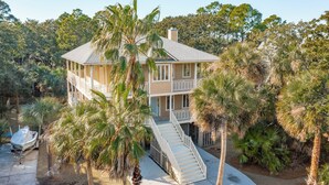 A two-story house with a balcony and a staircase leading to the upper level. - 30-Day Rental - Live in Beachside Luxury! 45 Lempesis (Folly Beach)