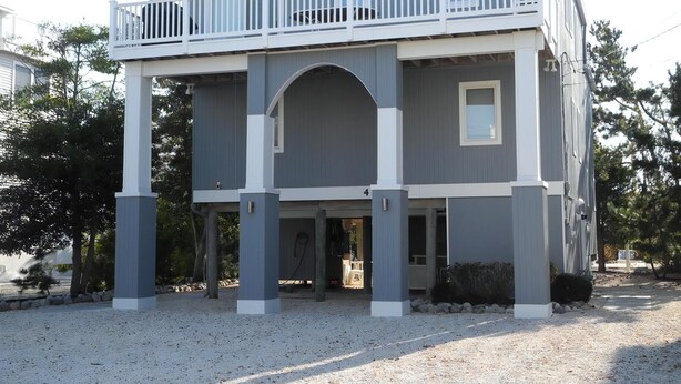 Ein zweistöckiges Haus mit Balkon, überdachter Veranda und Garage.