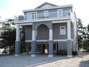 Ein zweistöckiges Haus mit Balkon, überdachter Veranda und Garage.