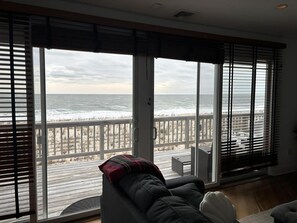 Una habitación con un amplio ventanal corredizo que da a un balcón con vistas al océano.