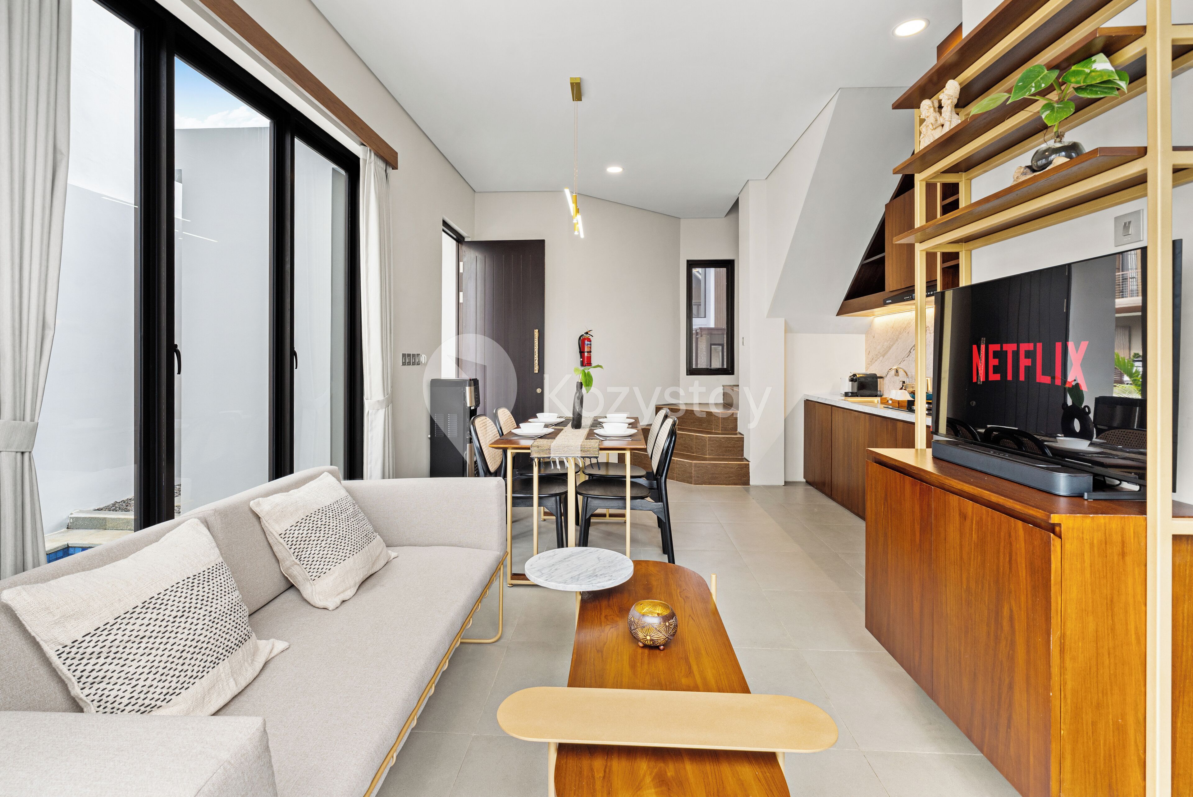 A modern living room with a sofa, coffee table, and a TV displaying the Netflix logo.