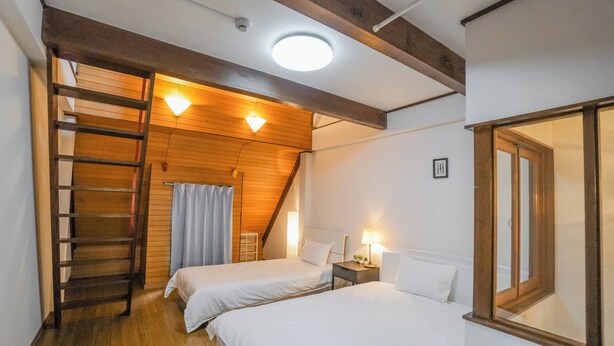 A bedroom with two beds, a wooden ladder, a ceiling light, and a window with a wooden frame. - HANASTAY NODA (Osaka)