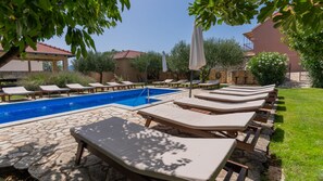 A poolside area with lounge chairs and a swimming pool.