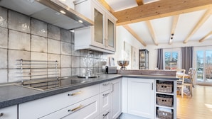 A modern kitchen with white cabinets, a granite countertop, and a wooden ceiling. - Holiday Home 'Hof Vilmnitz 22 B' with Private Terrace, Private Garden and Wi-Fi (Putbus)