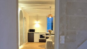 A staircase leading to a room with a kitchen area, a dining table, and a chair. - Comfortable cocoon 400m from Saumur cellars, close to golf course, IFCE, Loire... (Saumur)