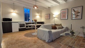 A modern living space with a kitchen, dining area, and a cozy seating area with a sofa and a coffee table. - Comfortable cocoon 400m from Saumur cellars, close to golf course, IFCE, Loire... (Saumur)