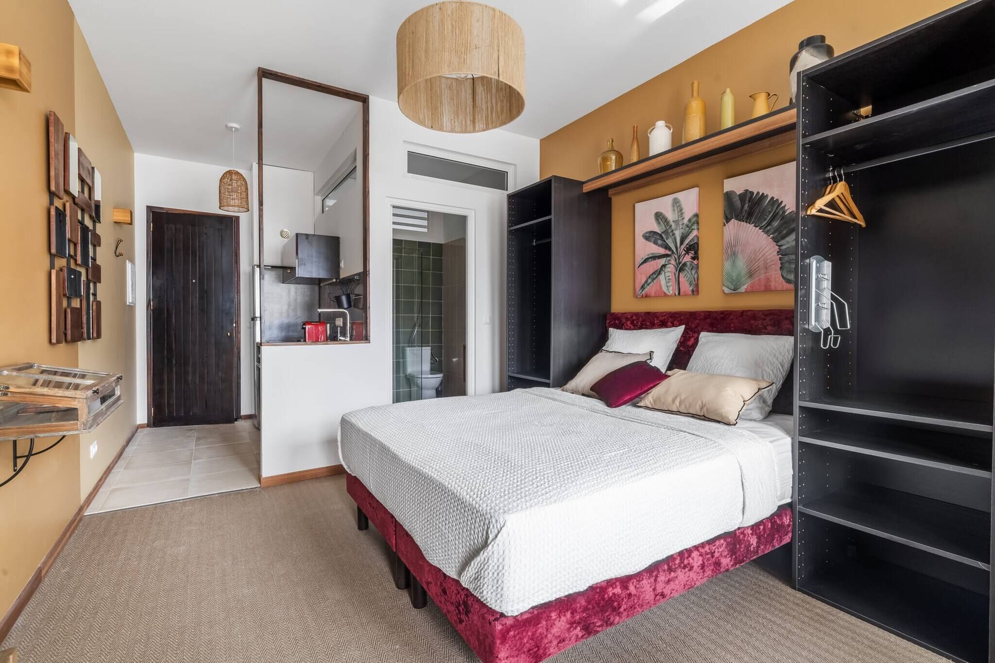 Une chambre à coucher avec un lit, une armoire et un miroir.