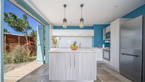 A modern kitchen with a central island, stainless steel appliances, and a view of the backyard. - 2 Villas with 2 Swimming Pools (Sainte-Luce)