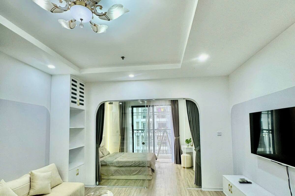 Una sala moderna con sofá, mesa de centro, televisor y ventilador de techo.