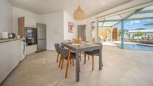 Una cocina moderna con comedor, piscina y vistas al exterior.