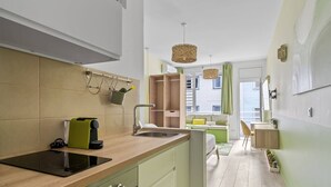 Eine moderne Küche mit Einbauherd, Spüle und Arbeitsplatte. Durch einen offenen Durchgang ist ein Essbereich mit Tisch und Stühlen zu sehen.
