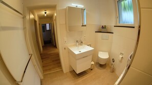 A bathroom with a sink, toilet, and mirror.