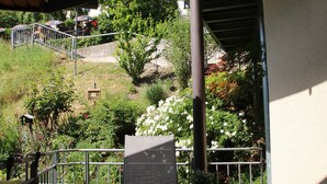 Een balkon met een metalen hekwerk, een stoel en een tafel.