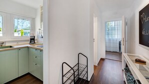A kitchen with a coffee maker, a metal rack, and a chalkboard with writing. - Apartment 'Andrea' with Balcony and Wi-Fi (Langenargen)
