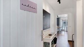 A hallway with a chalkboard, a nameplate, a table, and chairs. - Apartment 'Andrea' with Balcony and Wi-Fi (Langenargen)
