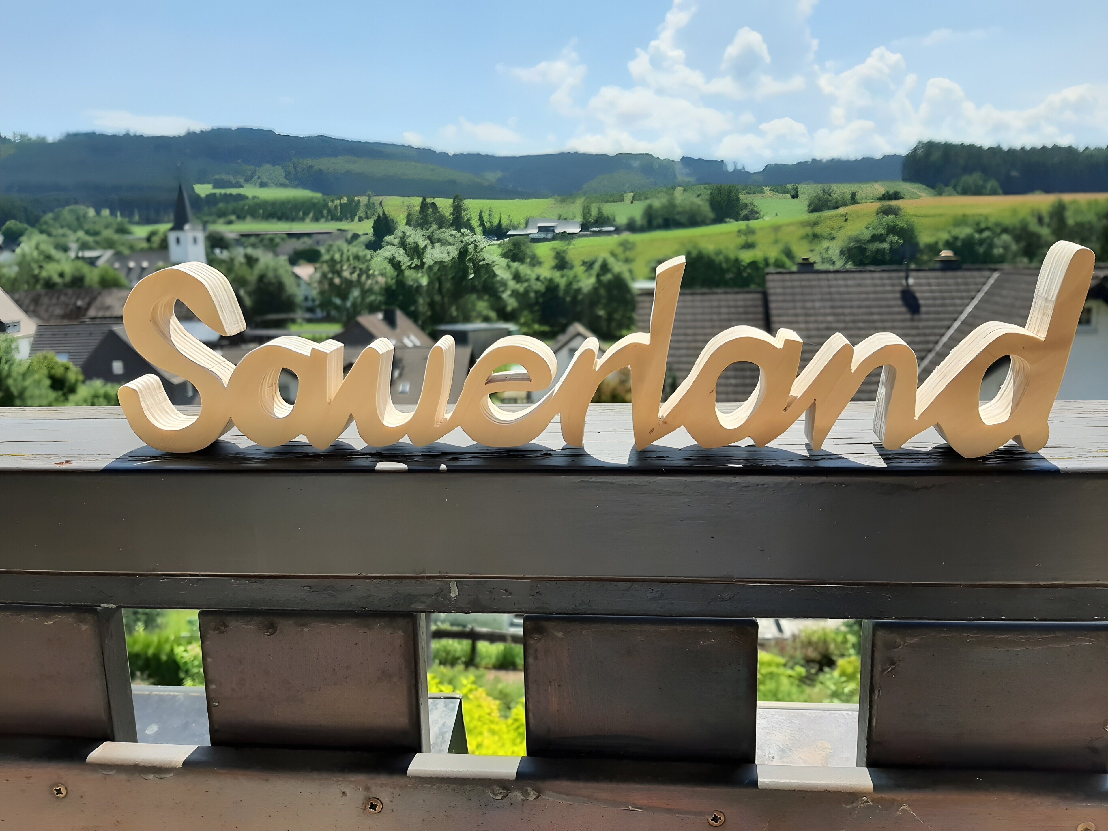 A wooden sign with the name 'Sauerland' on a metal railing.