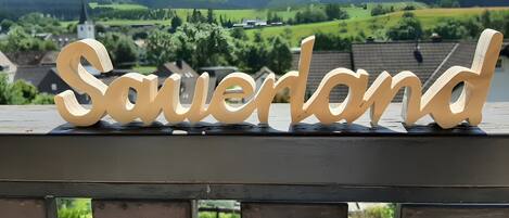 A wooden sign with the name 'Sauerland' on a metal railing.