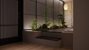 A modern interior with a wooden floor, a low bench, and a vertical garden with plants and rocks. - Koum Ryokan Hotel Gijang by Anook (Busan)