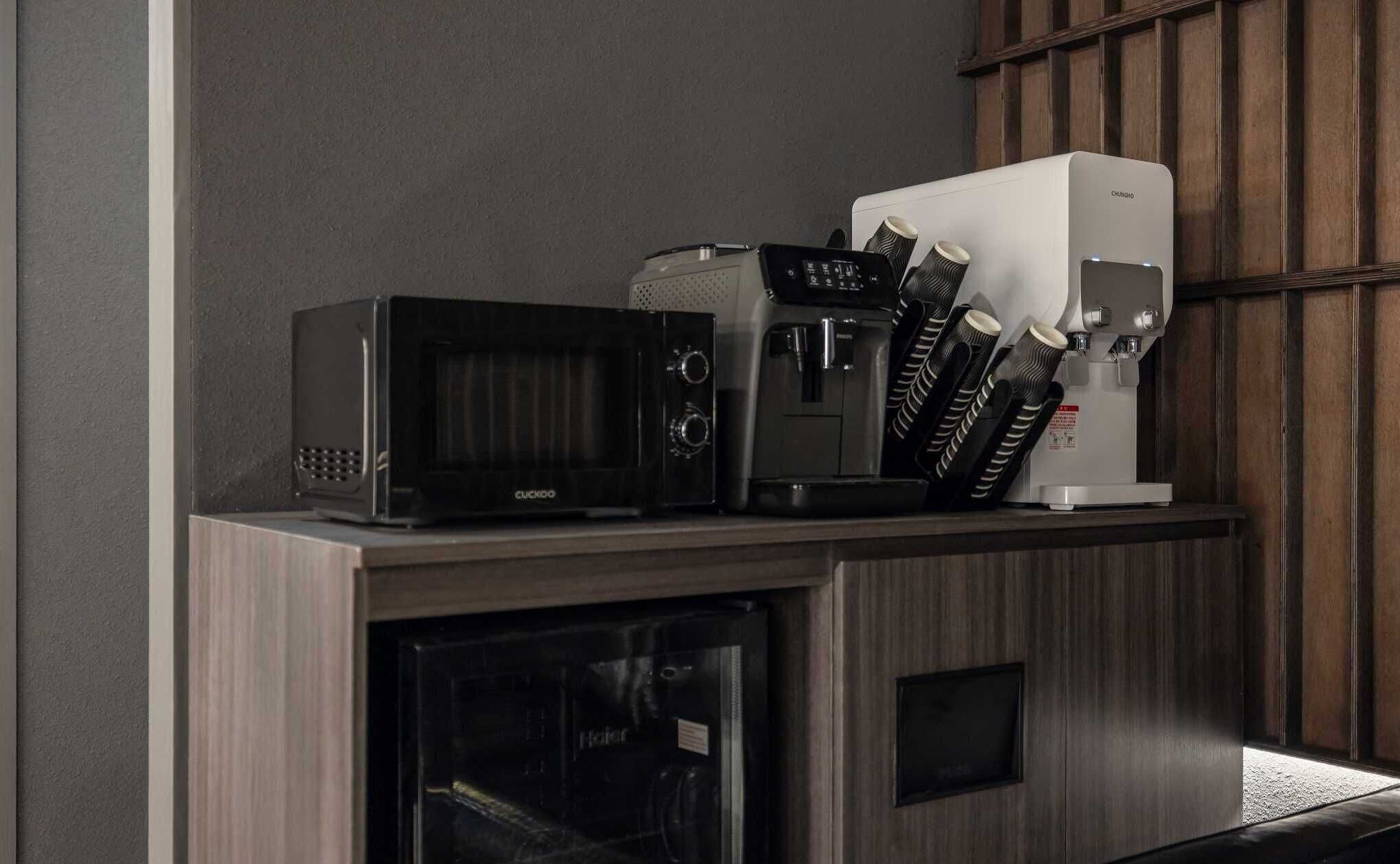 Un coin cuisine équipé d’un four à micro-ondes, d’une machine à café et d’un réfrigérateur.