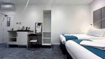 Hotellihuone, jossa on sänky, työpöytä, tuoli, vaatekaappi ja kylpyhuone.